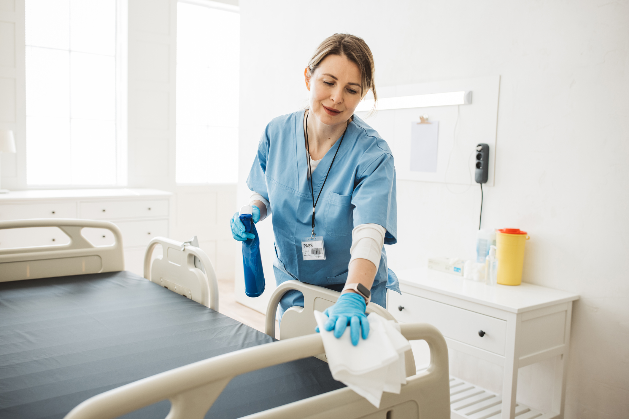 woman nurse in hospital wiping down bed