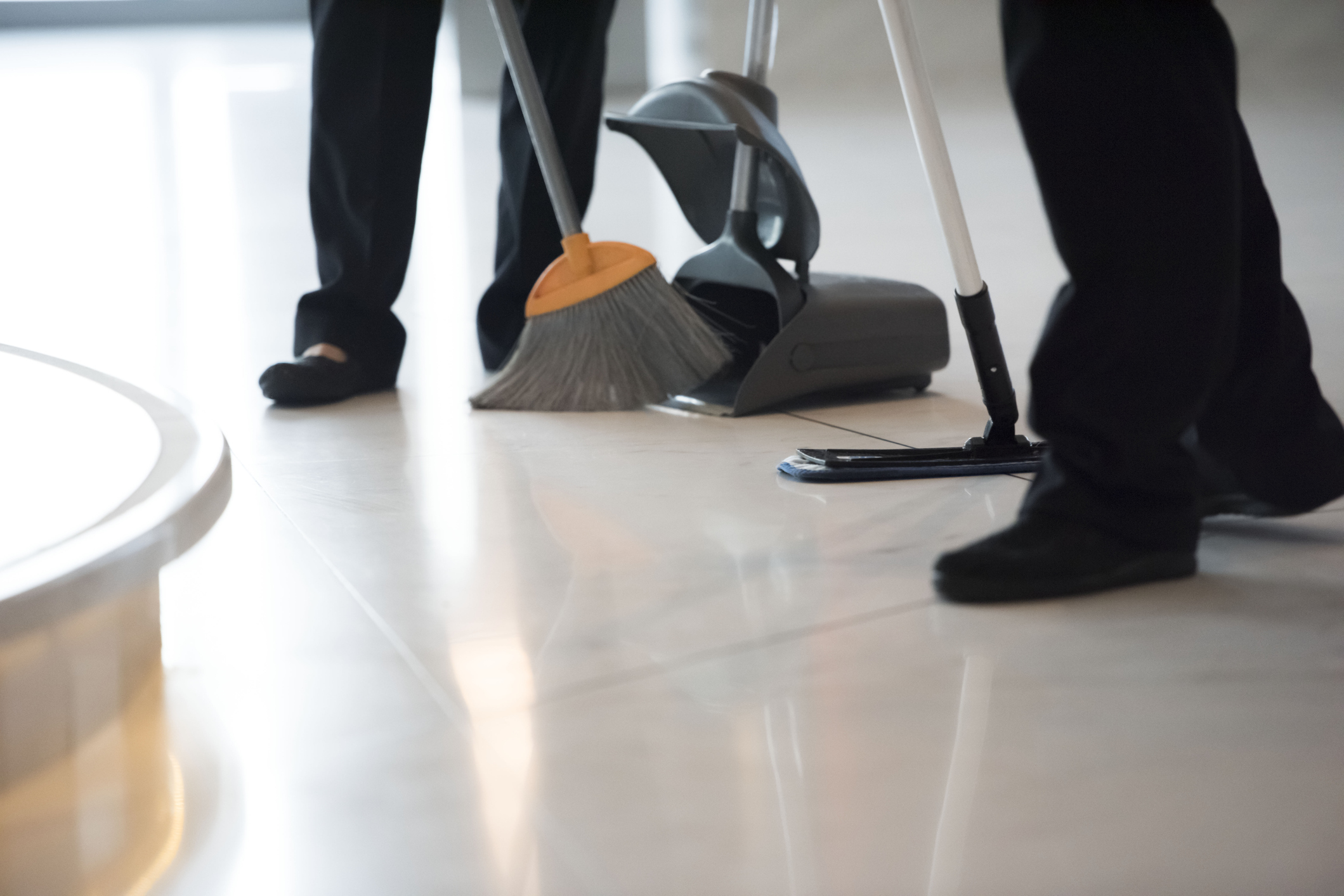 sweeping floor with broom into dustpan